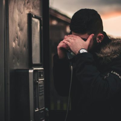 Photo by Nikolaos Dimou Man Wearing Black Parka Jacket Holding Telephone